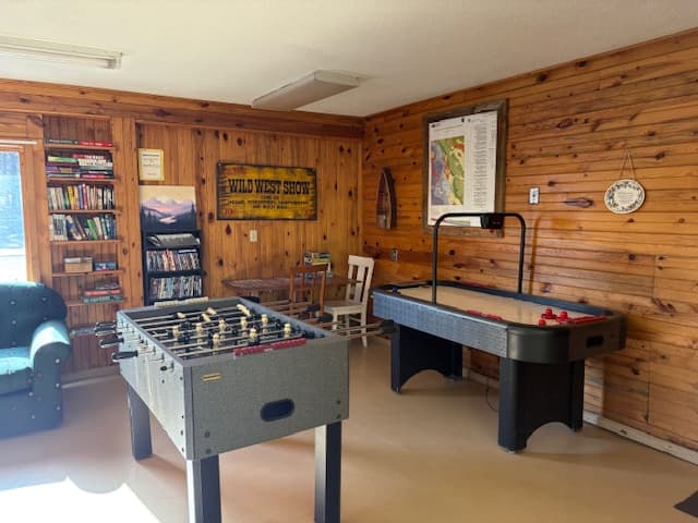 Indoor game room with arcade games and pool tables at Rush No More