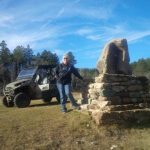 Woman and ATV leaning on rock pile